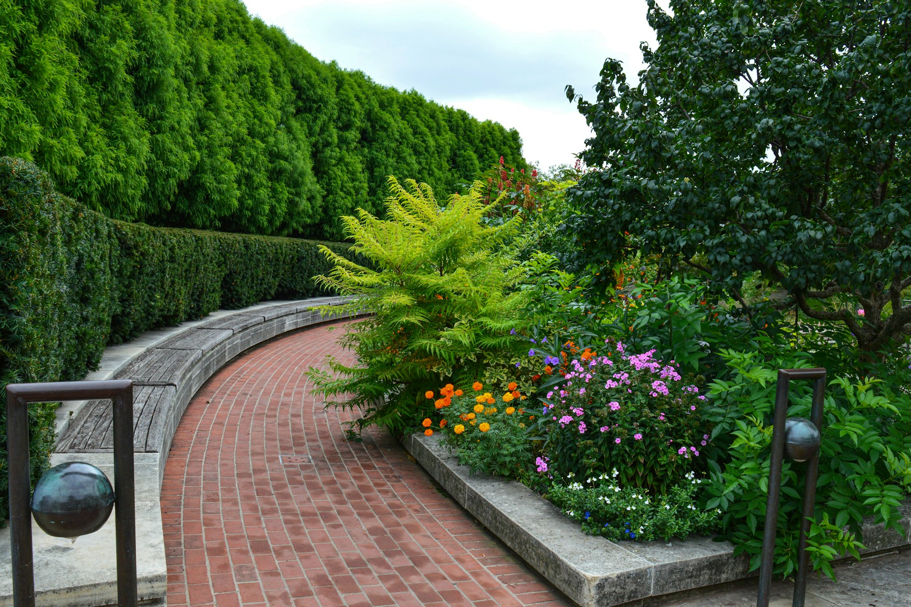 A brick garden path surrounded by maintained planting beds